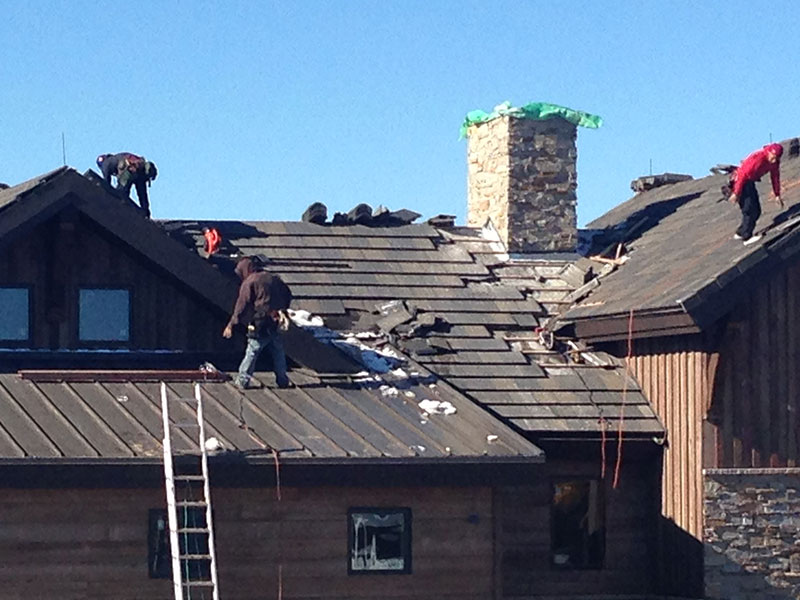 Roofers working on a slate residential roofing project